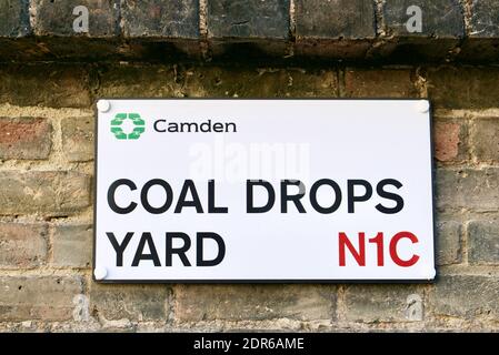 Coal Drops Yard Straßenschild auf Ziegelmauer in London Borough of Camden. Coal Drops Yard ist ein Einkaufs-und Gastgewerbe Bereich in Kings Cross Entwicklung Stockfoto