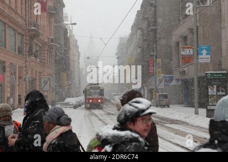 Fußgänger überqueren die Straße bei starkem Schneefall in der Jindřišská-Straße in Nové Město (Neustadt) in Prag, Tschechische Republik. Im Hintergrund ist der Jindřišská-Turm (Jindřišská věž) zu sehen. Stockfoto