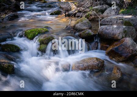 Flusswasser fließt zwischen den Felsen und bildet kleine Wasserfälle, Rascafría, Madrid, Spanien Stockfoto