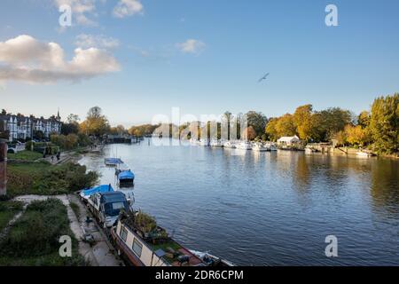 Blick von der Hampton Court Bridge auf die Molesey Lock, Surrey, der Themse, mit Booten und Yachten, die im Herbst an den Ufern entlang fahren Stockfoto