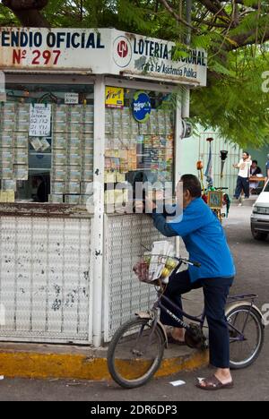 Ein Mann auf dem Fahrrad kauft eine Lotterie in Uman, Yucatan, Mexiko Stockfoto