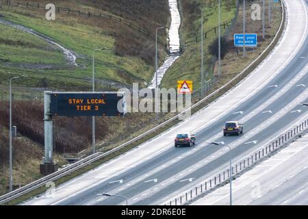 Autobahn-Matrix-Zeichen Staaten bleiben lokal, Tier 3 auf der M62 in West Yorkshire, unter lokalen Coronavirus Tier-System-Einschränkungen, England Großbritannien Stockfoto