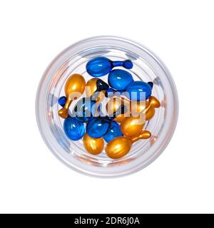 Gold und blau Gesicht Kapseln in Glas. Feuchtigkeitsspendendes Gesichtsserum. Stockfoto