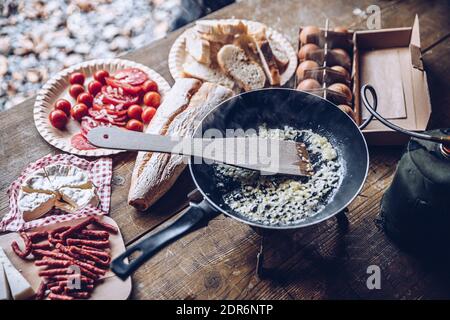 Bratzwiebel für Rühreier in den Bergen. Tourist Frau bereitet köstliche touristische Frühstück im Freien. Stockfoto