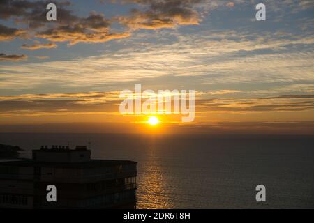 Schöner Sonnenaufgang am Meer von der Stadt aus gesehen Stockfoto