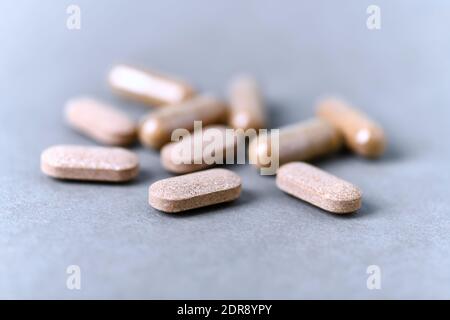 Ashwagandha (Withania somnifera) Tabletten und Kapseln auf Papier Hintergrund. Nahaufnahme. Stockfoto