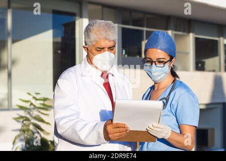 Latein-Team von Ärzten schauen auf Kamera und Lächelnd, während man vor dem mexikanischen Krankenhaus in Mexiko-Stadt steht Oder lateinamerika Stockfoto