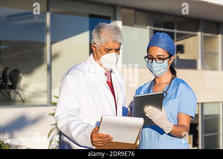 Latein-Team von Ärzten schauen auf Kamera und Lächelnd, während man vor dem mexikanischen Krankenhaus in Mexiko-Stadt steht Oder lateinamerika Stockfoto