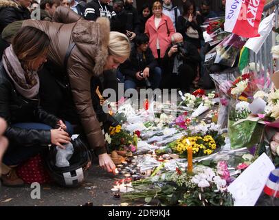 Menschen hinterlassen Blumen entlang einer Bahnschnur in der Nähe des Bataclan-Theaters im 11. Bezirk von Paris am 14. November 2015 wurden nach den Terroranschlägen in Paris am 13. November mindestens 129 Menschen getötet und 352 weitere verletzt - davon 99 in kritischem Zustand. Foto von Somer/ABACAPRESS.COM Stockfoto