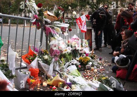 Menschen hinterlassen Blumen entlang einer Bahnschnur in der Nähe des Bataclan-Theaters im 11. Bezirk von Paris am 14. November 2015 wurden nach den Terroranschlägen in Paris am 13. November mindestens 129 Menschen getötet und 352 weitere verletzt - davon 99 in kritischem Zustand. Foto von Somer/ABACAPRESS.COM Stockfoto