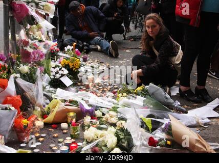 Menschen hinterlassen Blumen entlang einer Bahnschnur in der Nähe des Bataclan-Theaters im 11. Bezirk von Paris am 14. November 2015 wurden nach den Terroranschlägen in Paris am 13. November mindestens 129 Menschen getötet und 352 weitere verletzt - davon 99 in kritischem Zustand. Foto von Somer/ABACAPRESS.COM Stockfoto