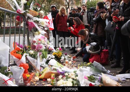 Menschen hinterlassen Blumen entlang einer Bahnschnur in der Nähe des Bataclan-Theaters im 11. Bezirk von Paris am 14. November 2015 wurden nach den Terroranschlägen in Paris am 13. November mindestens 129 Menschen getötet und 352 weitere verletzt - davon 99 in kritischem Zustand. Foto von Somer/ABACAPRESS.COM Stockfoto