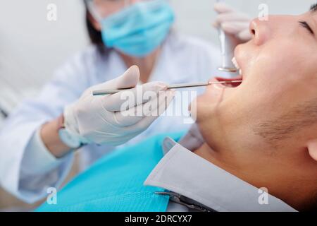 Überprüfung der Zähne des männlichen Patienten Stockfoto