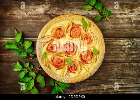 Draufsicht auf Apfelkuchen mit rosa Apfel verziert und grünen Blättern. Draufsicht. Stockfoto