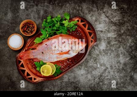Frische Tilapia mit Gewürzen und Zitrone. Draufsicht. Speicherplatz kopieren. Stockfoto