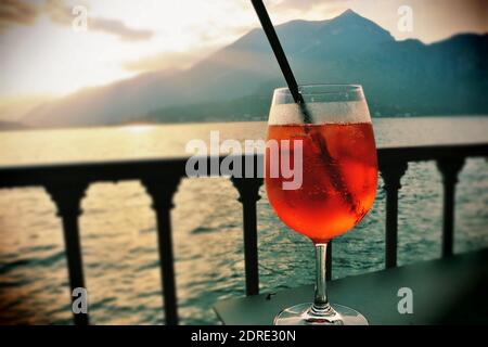 Genießen Sie einen erfrischenden Aperitif bei Sonnenuntergang am Comer See. Stockfoto