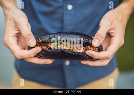 Vietnamesisches Schweinefleisch Banh Mi Sandwich in einem schwarzen Baguette Stockfoto