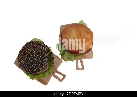 Zwei Hamburger auf Holz Schneidetische isoliert auf weißem Hintergrund flach legen. Das Bild enthält den Kopierbereich Stockfoto