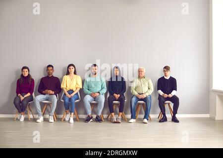 Gruppe von verschiedenen Menschen warten auf ihre an der Reihe zu sehen Einen Arzt oder ein Vorstellungsgespräch zu haben Stockfoto