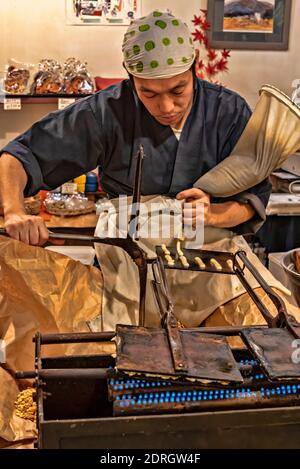 Kochen Sie in einem Plätzchen-Imbiss, Nishiki-Markt, Kyoto, Japan Stockfoto