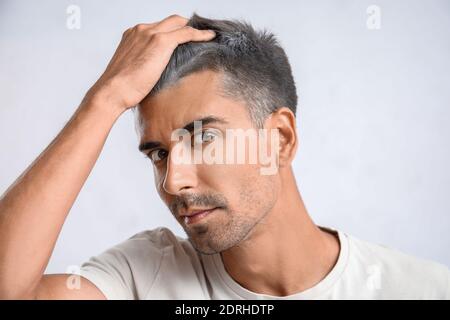 Mann mit grauem Haar auf hellem Hintergrund Stockfoto