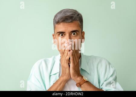 Gestresster Mann mit grauem Haar auf farbigem Hintergrund Stockfoto