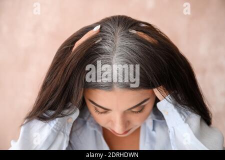 Gestresste Frau mit grauem Haar auf farbigem Hintergrund Stockfoto