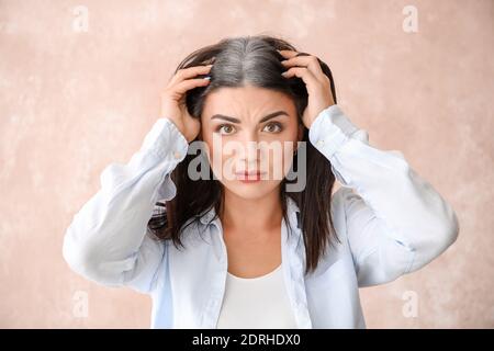 Gestresste Frau mit grauem Haar auf farbigem Hintergrund Stockfoto