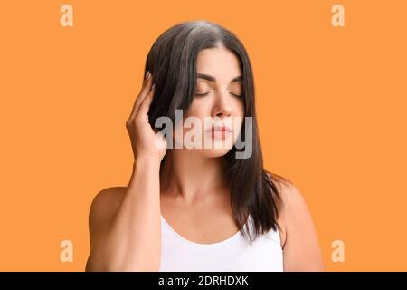 Gestresste Frau mit grauem Haar auf farbigem Hintergrund Stockfoto