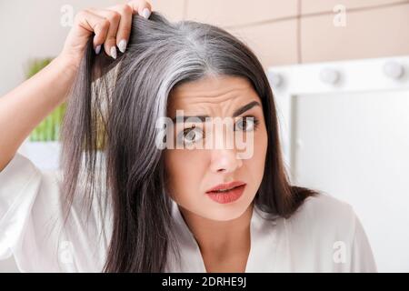 Gestresste Frau mit grauem Haar zu Hause Stockfoto