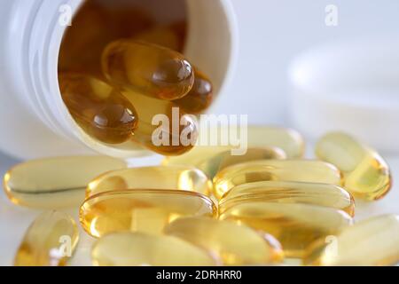 Goldene Kapseln werden aus dem weißen Glas gegossen Stockfoto