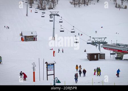 Skipisten wegen Pandemie über Weihnachten geschlossen, nur wenige Touristen mit Kindern spielen im Schnee mit Bob. Sestriere, Italien - Dezember 2020 Stockfoto