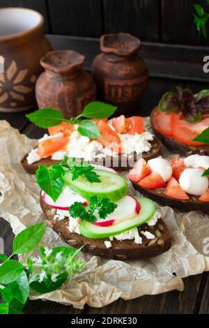 Verschiedene Toast Sandwiches mit Eiern, Radish, Tomaten, Gurke, Avocado und Paprika, vertikale Bild Stockfoto