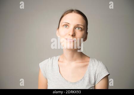 Ziemlich lächelnd freudig weiblich mit starken Haaren, lässig gekleidet, mit Zufriedenheit auf die Kamera schauen, glücklich sein. Studioaufnahme eines schönen Be Stockfoto