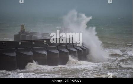 Brighton UK 21. Dezember 2020 - Wellen schlagen heute über die Westwand der Brighton Marina, während starke Winde und heftiger Regen entlang der Südküste ziehen : Credit Simon Dack / Alamy Live News Stockfoto