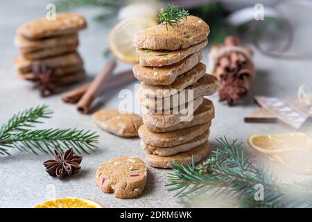 Gestapelte würzige Butterkekse mit kandierten Früchten, Zimtstangen und Anis. Festliche Weihnachten oder Neujahr Hintergrund mit Tannenzweigen und getrockneten oran Stockfoto