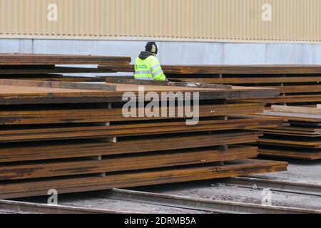 Stevedore laden Stahl zu Schiff im Hafen Stockfoto