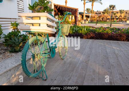 Alte blaue dekorative Fahrrad mit Blumen - Straße oder Garten Dekoarationsideen Stockfoto