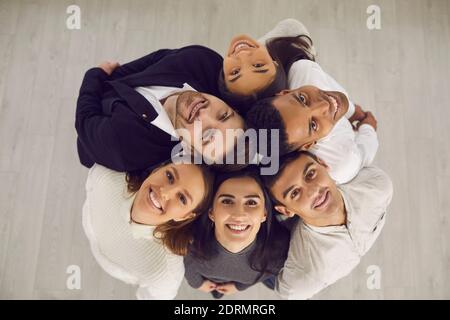 Gruppe von glücklichen verschiedenen Geschäftsleuten stehen im Kreis und Blick auf die Kamera Stockfoto