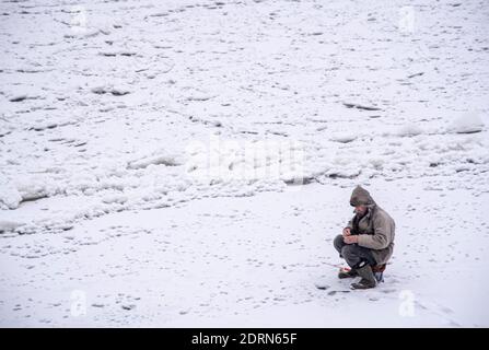 Russland, Tuchkovo, Dezember 2020, EIN eingeflügelter Fischer auf einem Winter Angelausflug. Stockfoto