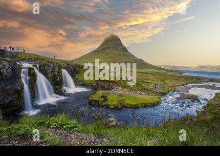 Ein schöner Sonnenuntergang gegen den Mount Kirkjufell und Kirjufellfoss Wasserfall in Grundarfjorour, Island Stockfoto