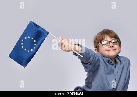 Lächelnder Junge mit der Flagge der Europäischen Union. Bildung in der EU. Die Behandlung in Europa Stockfoto
