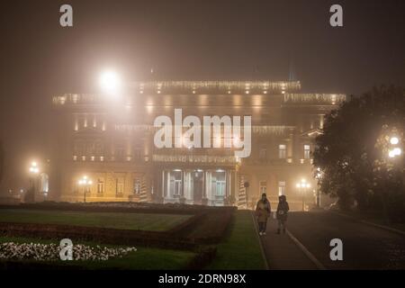 BELGRAD, SERBIEN - 26. NOVEMBER 2020: Menschen, die vor Stari Dvor, dem Rathaus von Belgrad, auch Skupstina genannt, in der Nacht, mit einem verschwommen Stockfoto