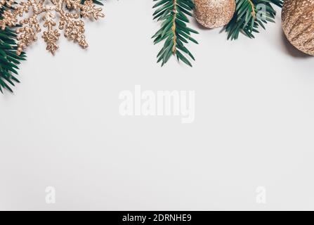 Weihnachtshintergrund mit Fichtenzweigen und goldenen Glitzer-Kugeln und Schneeflocke oder Sterne Dekorationen alle auf weißem Hintergrund gelegt. Speicherplatz kopieren mit Stockfoto