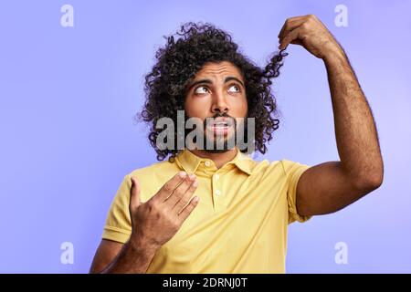 Lustige arabische Mann denkt über Friseur. Müssen lange hait schneiden, Blick auf Spliss Stockfoto