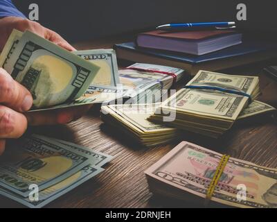 Nahaufnahme der Hände, die große Mengen an Bargeld zählen. Stockfoto