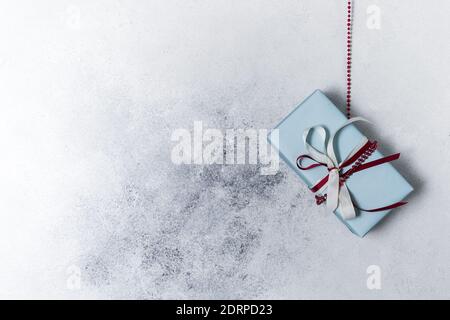 Rustikale Retro-Geschenke hängen auf einer Girlande, echte Boxen auf einem hellen Hintergrund. Weihnachten, Vintage-Stimmung. Handgemachte Öko-Papier-Verpackung Stockfoto