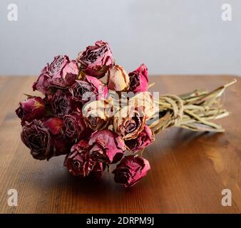 Schöner Strauß getrockneter Rosen auf einem Holztisch Stockfoto