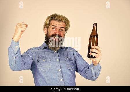 Glücklicher Mann hält volle Glasflasche in der Hand. Männlich hält Flasche Bier. Hipster Rest in Pub. Sportliebhaber Kopf hoch. reifen Mann hält eine Glasflasche Bier. Betrunken Hipster männlichen Handwerk Flaschenbier. Stockfoto
