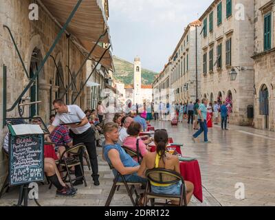 Dubrovnik, Dubrovnik-Neretva, Kroatien. Touristen entspannen sich in einem Straßencafé in Stradun. Stockfoto